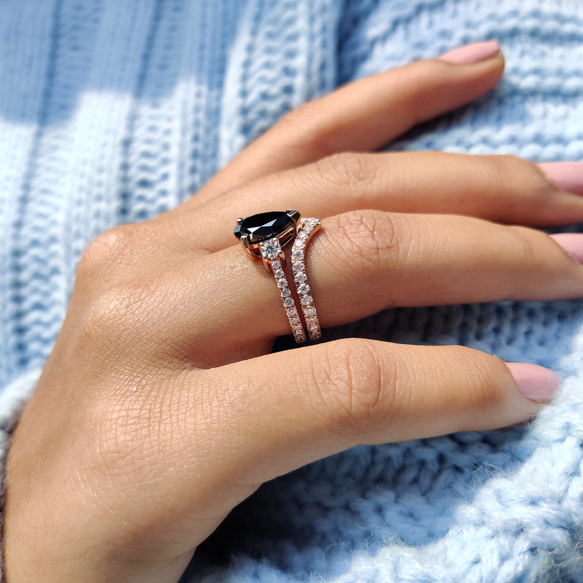 Pear cut engagement ring with black Moissanite and round side stones.
